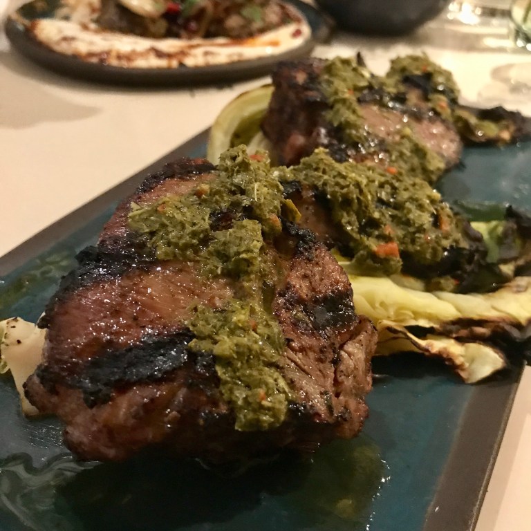 lamb chops marinated in kabsa spices & plums then grilled, charcoaled hispi cabbage, vine leaves chimichurri