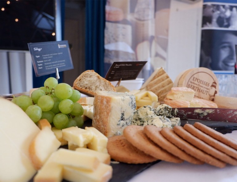 Cheese, crackers, fruit laid out for cheese tasting