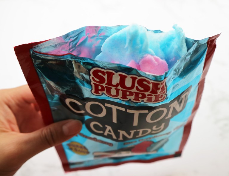 Candy floss packet is open with the pink and blue candy floss sticking out