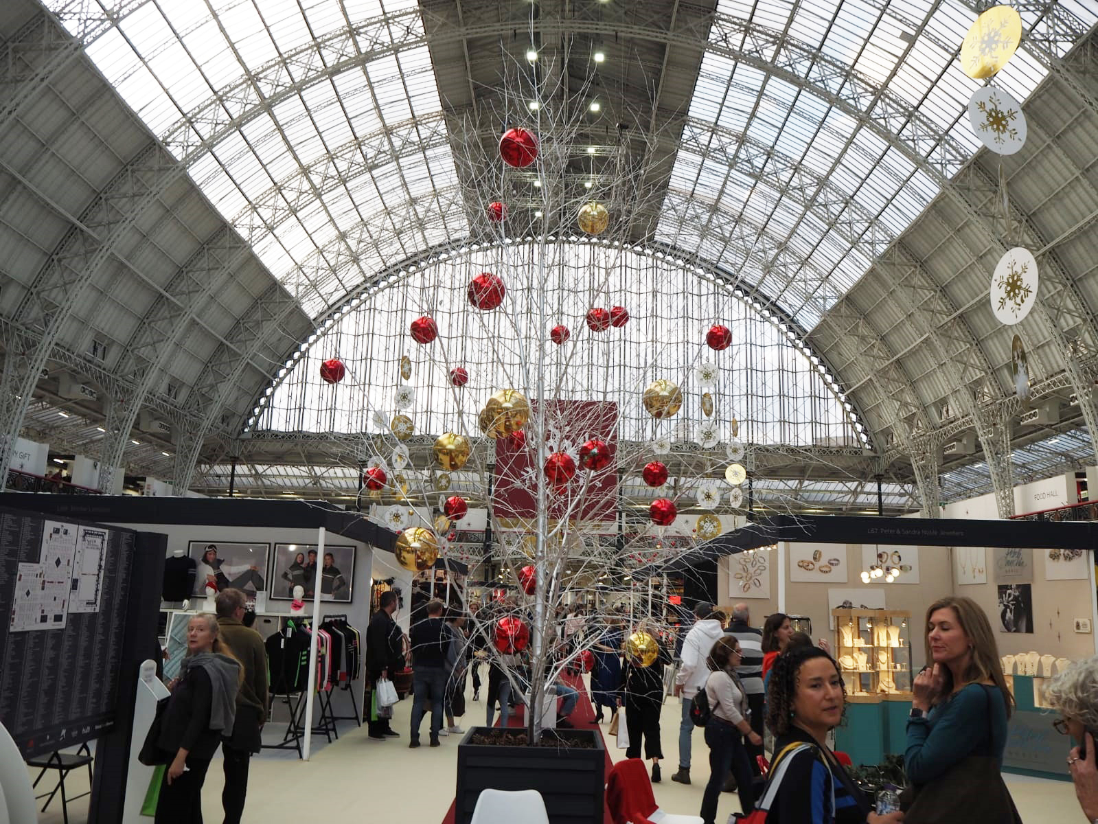 Ground view of the fair with a silver sparkly tree in the middle, red and gold baubles hung sporadically