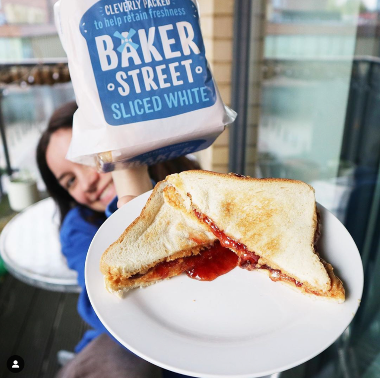 Claire holding a plate with jam oozing out of the sandwich